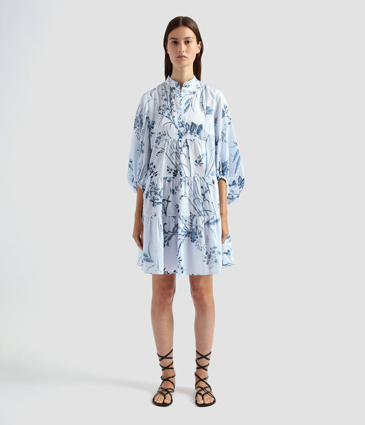 A tiered dress perfect for summer. This cotton poplin dress has large blouson sleeves with a tiered skirt and relaxed silhouette. A stand collar and floral palm print give this tiered dress a classic feel. 