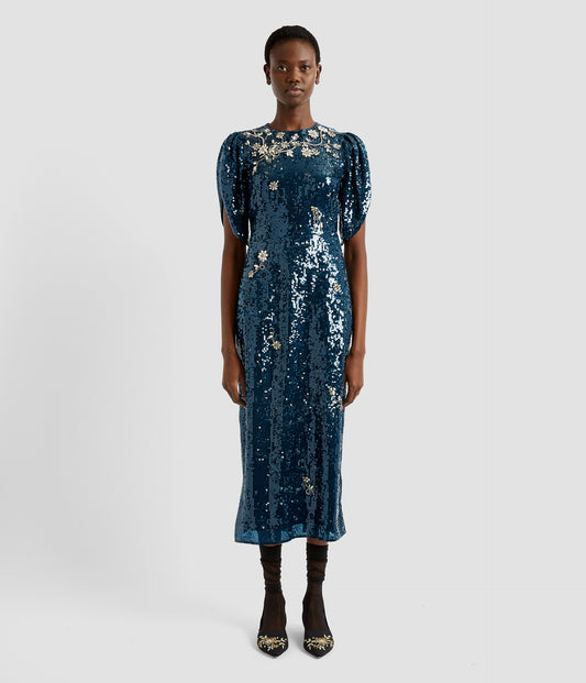 A mid length sequined dress in petrol blue sequins with tulip sleeves. The dress catches the light beautifully with additional floral crystals around the neckline. 