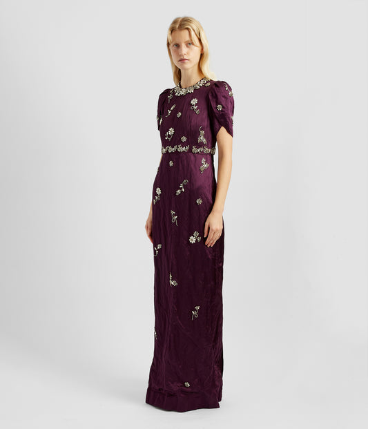 Embroidered gown by designer Erdem. The full length embroidered gown is slim fitting with tulip sleeves  and embellished embroiderey around the neck, waist and over the front of the dress. 