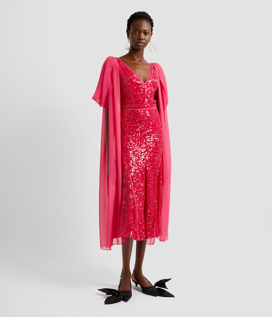 Midi draped dress in bright fuschia pink sequins. The midi dress is fitted with a v neck and dramatic draping over each shoulder that drapes from the shoulder to the hem. 