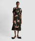An Aline midi dress with gathered sleeves with a tie detail. The midi dress features a crew neck and aline skirt in a black seersucker fabric that decorated with a traditional Rose print. 