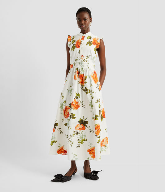 Elegant sleeveless midi dress in heavyweight white cotton poplin with orange and green rose print. The sleevelss midi dress features buttons down the bodice, a stand collar and a ruffles. 