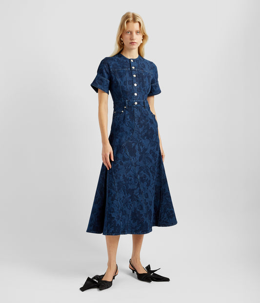 A denim midi dress that takes the functional fabric and elevates it into a luxurious dress. The denim midi dress features a floral print on indigo denim, buttones down the bodice and an A-line silhouette. 