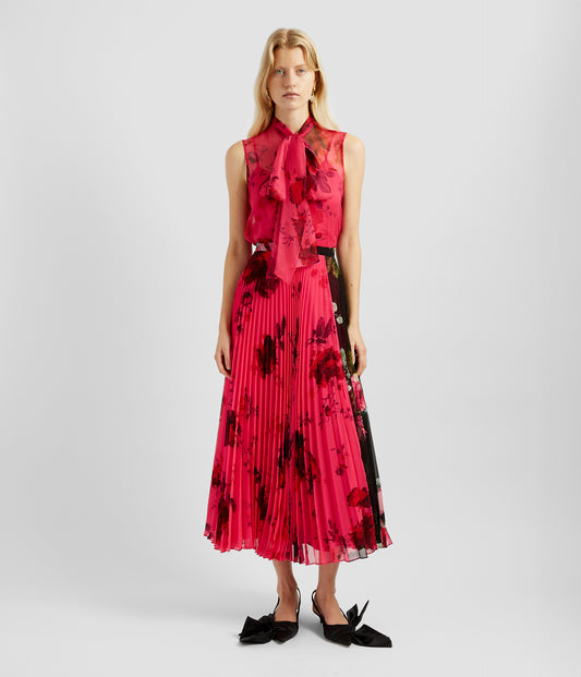 Pleated Midi Skirt in bright cerise pink with a large rose print. by designer Erdem. The pleated midi skirt is fitted at the waist and has a feminine silhouette over the hips  ending at midi length.