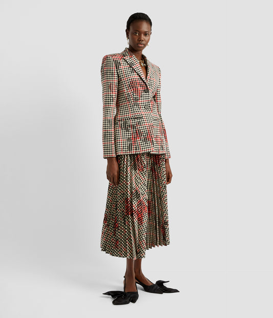 A pleated midi skirt in a wool blend checked fabric with over printed blooms. The pleated check midi skirt is worn with a matching single breasted blazer with the same check and floral fabric.