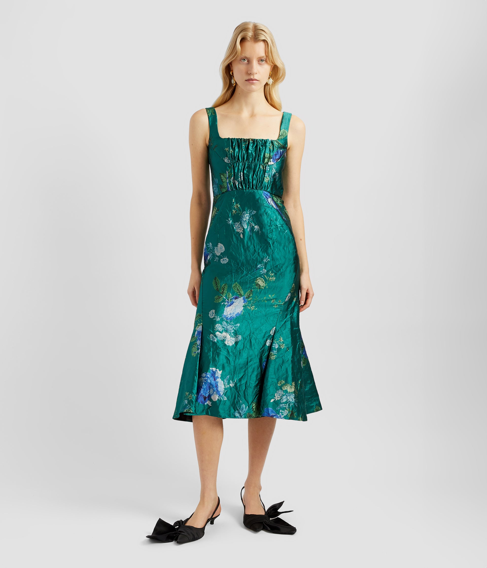 Gathered bodice dress in textured blue green teal satin. The gathered bodice features a square neckline with straps before going into a fit and flare midi skirt.