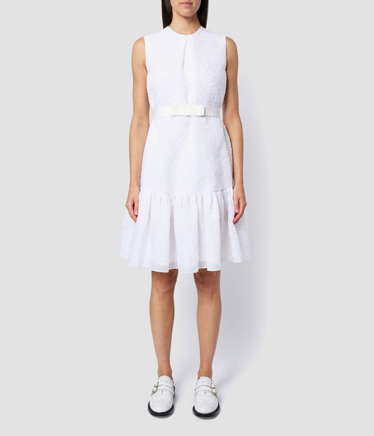 Maple dress by designer Erdem. The sleeveless short dress features a bow waist belt and a gathered tiered skirt. Made from white organza cloque suitable for a short wedding dress. 