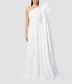 Asymmetric one-shoulder wedding dress with a large bow on the shoulder. The wedding dress is made from ivory organza with embroidered flowers that is fitted at the waist with a flared skirt. 