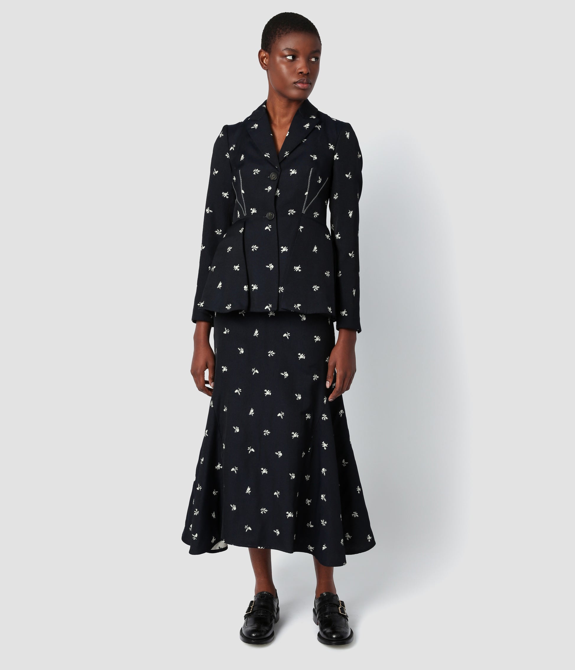 Flared skirt in a navy jacquard with a white ditsy floral print. The skirt is fitted over the hips but flares out to give an A-line silhouette.