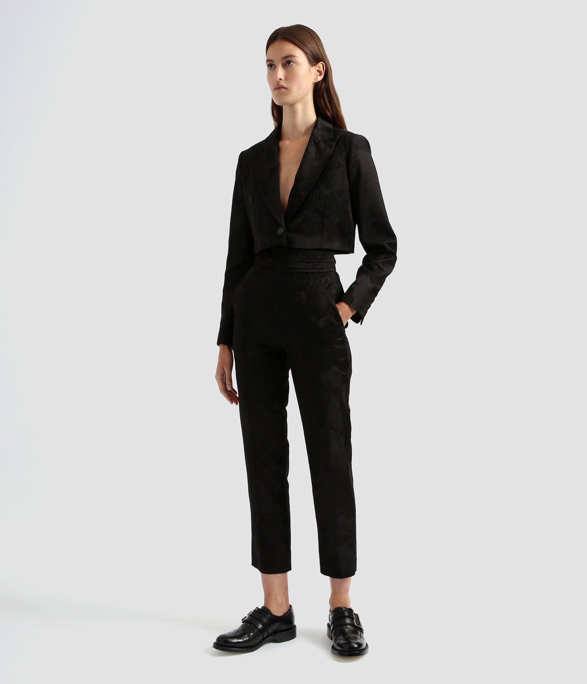 Tailored slim leg trousers for women by designer Erdem. The tailored trousers are crafted from a wool jacquard with a floral print. The tailored floral trousers are worn with a matching cropped boxy blazer.