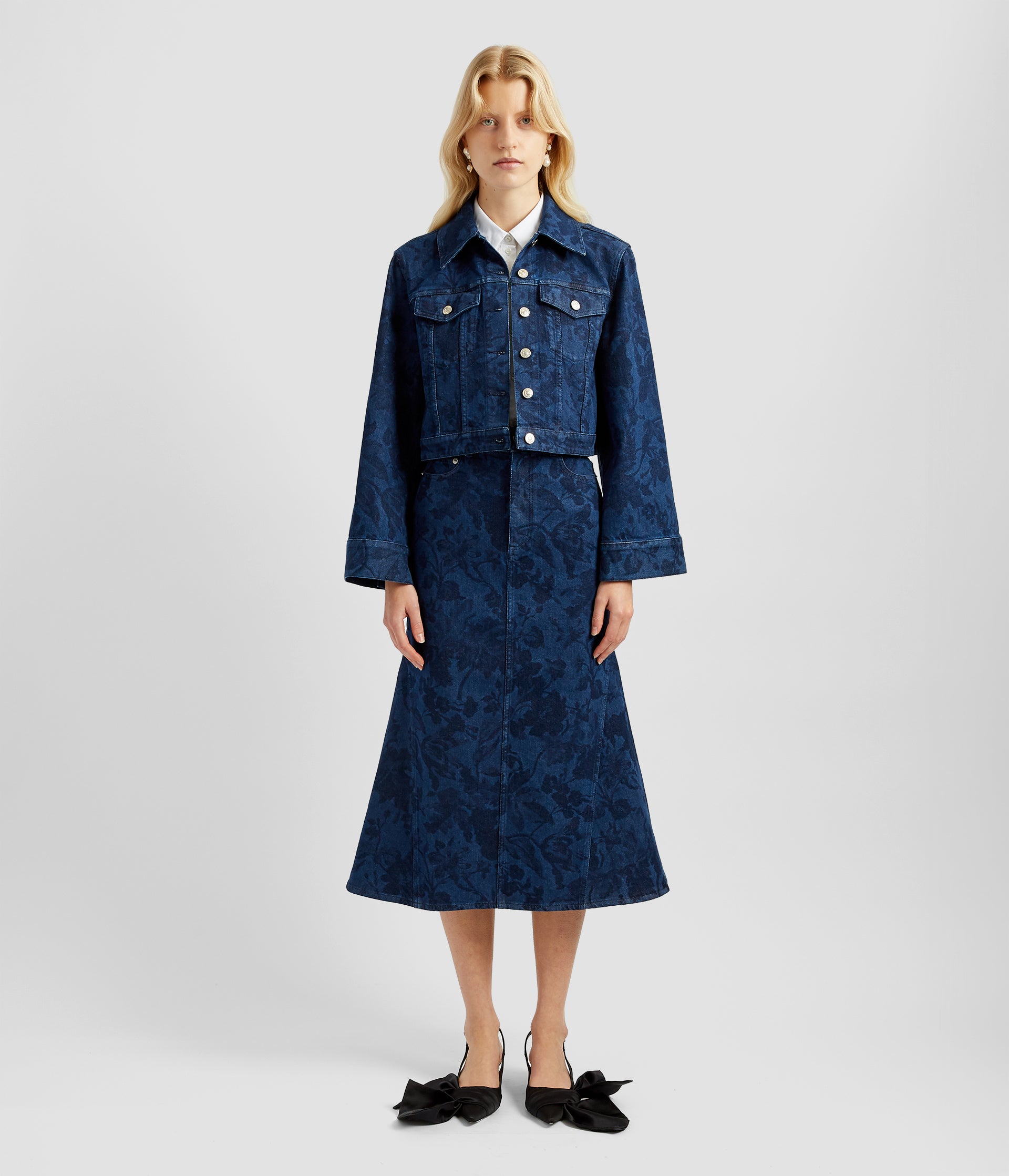 A cropped boxy floral print denim jacket with a wide sleeve that flares at the wrist, The boxy cropped floral denim jacket is worn with the matching floral aline midi skirt. 