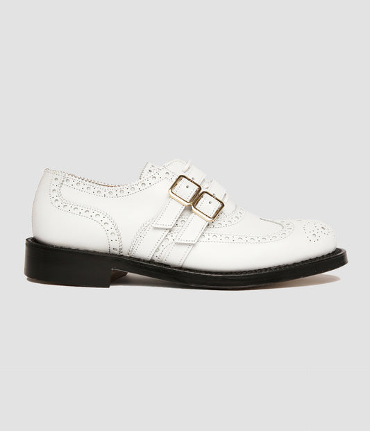 A pair of white leather brogue shoes for women by the designer ERDEM. The shoes feature classic brogue markings with a double monk strap fastening with gold buckles. 
