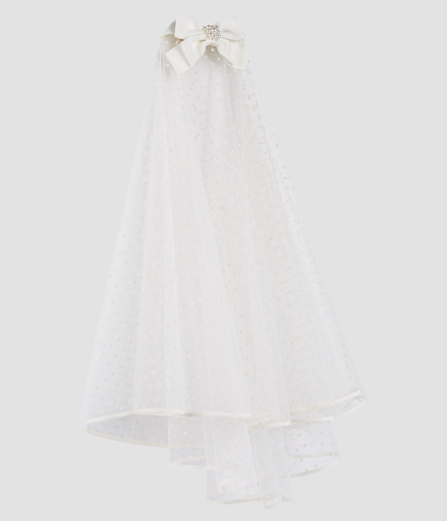 A beautiful shoulder length wedding veil with a polka dot pattern in the ivory tulle. The veil attaches delicately to the hair with a faux pearl bow. 